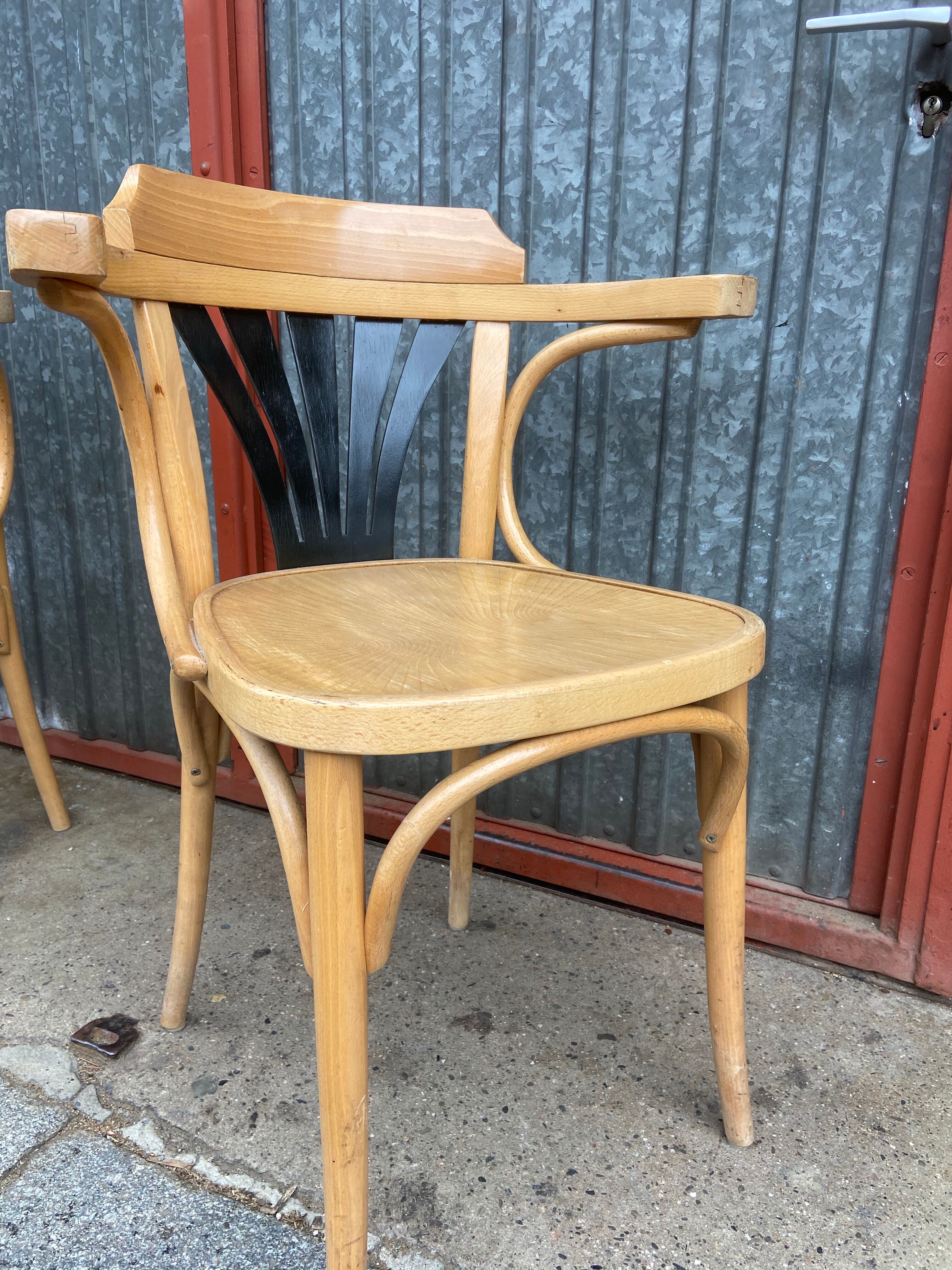 Pair of curved wooden bistro chairs with armrests