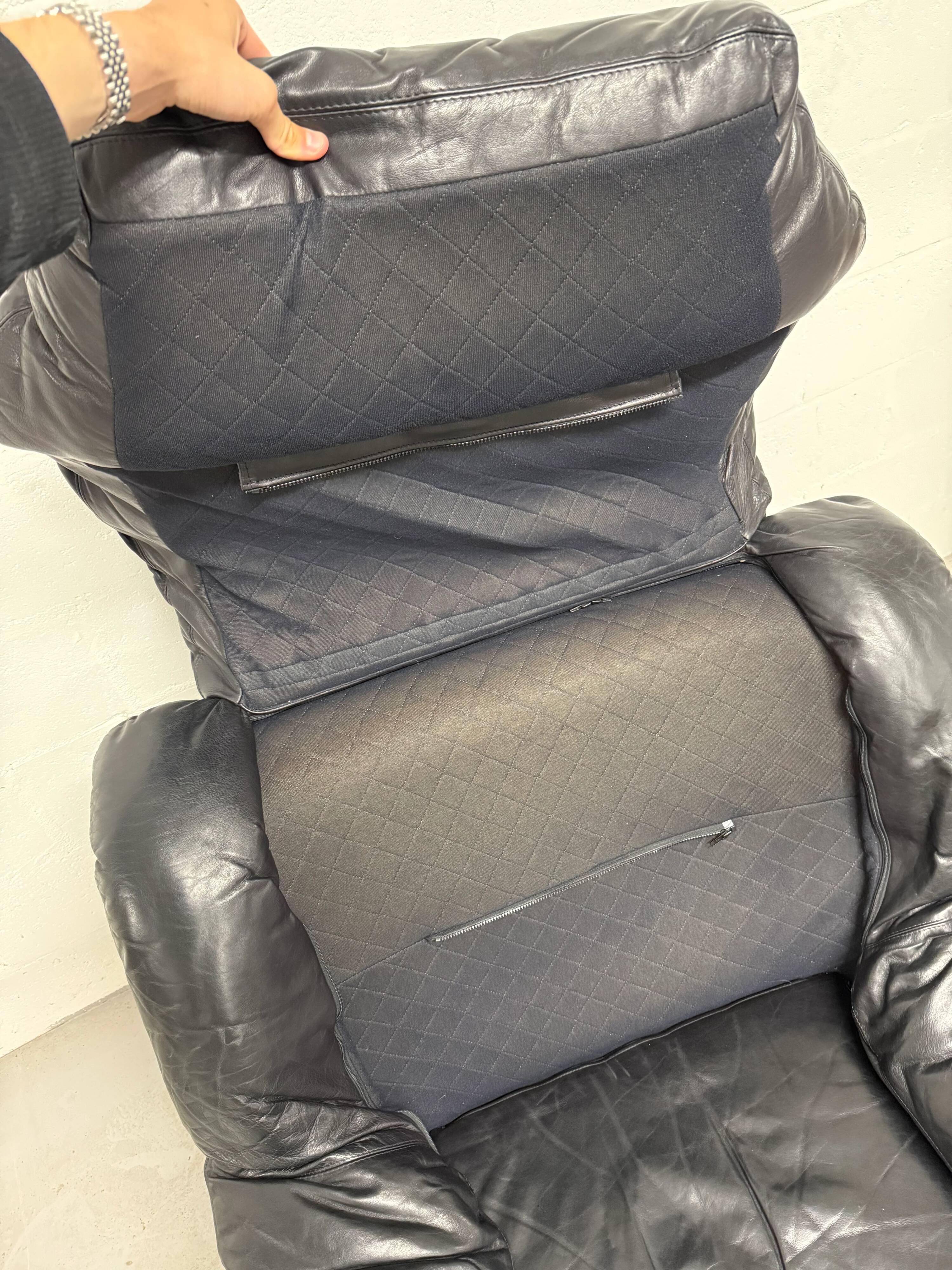 Vintage black leather lounge chair — low postmodern club chair from the space age.