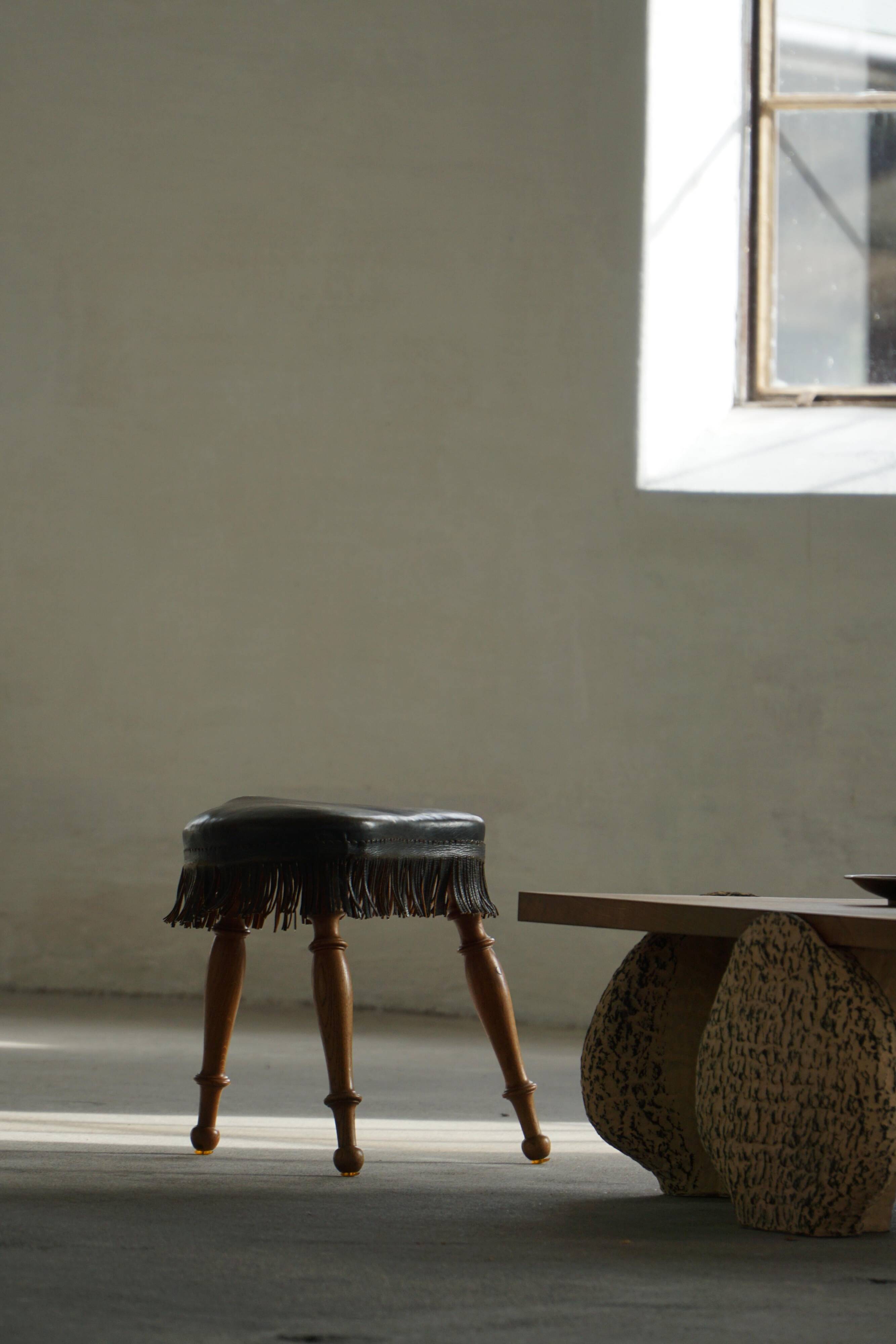 Danish oak tripod stool from the early 20th century with leather fringe, 1930s.
