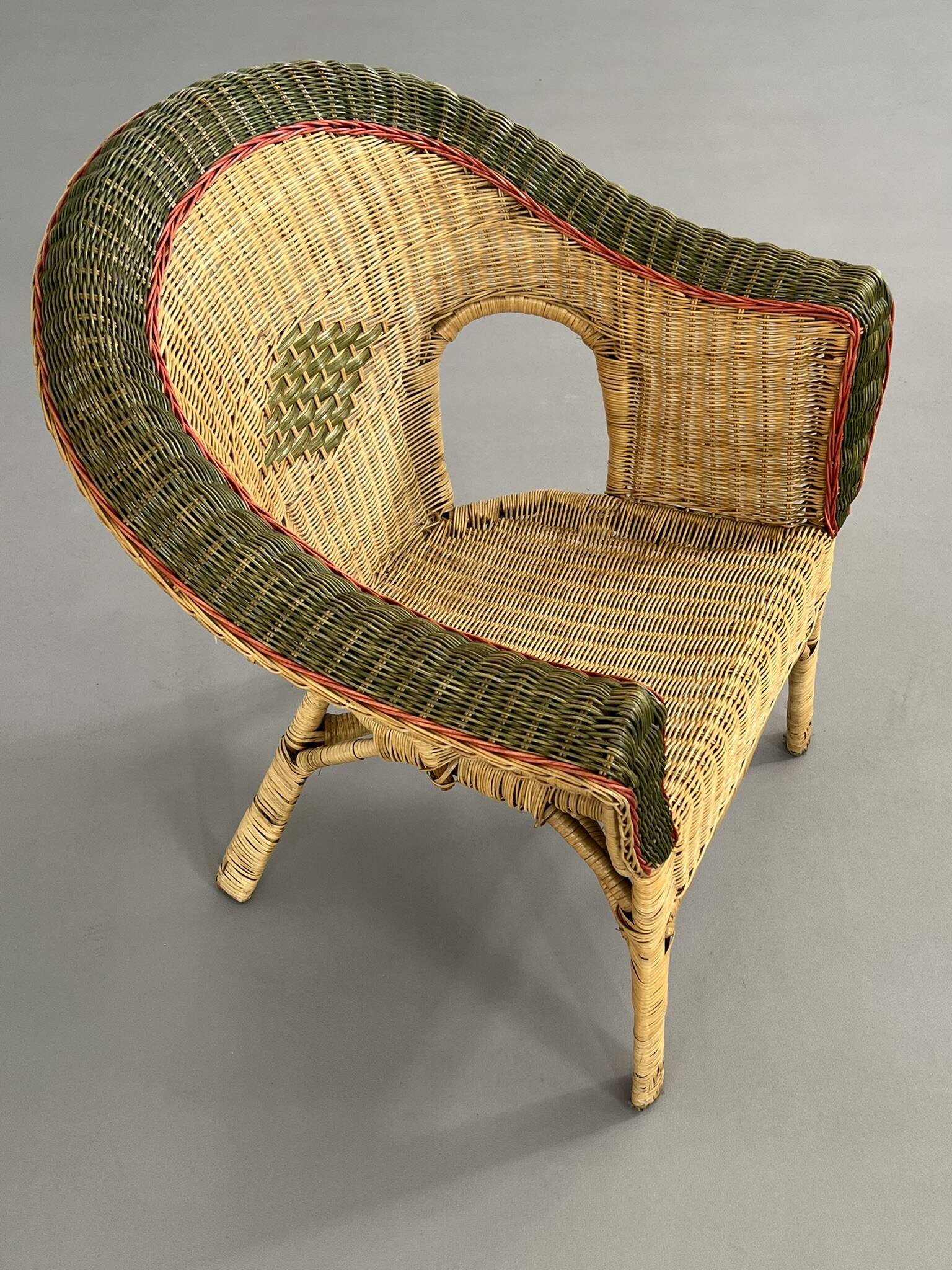 Cabriolet style armchair in rattan, wicker and green and red edging