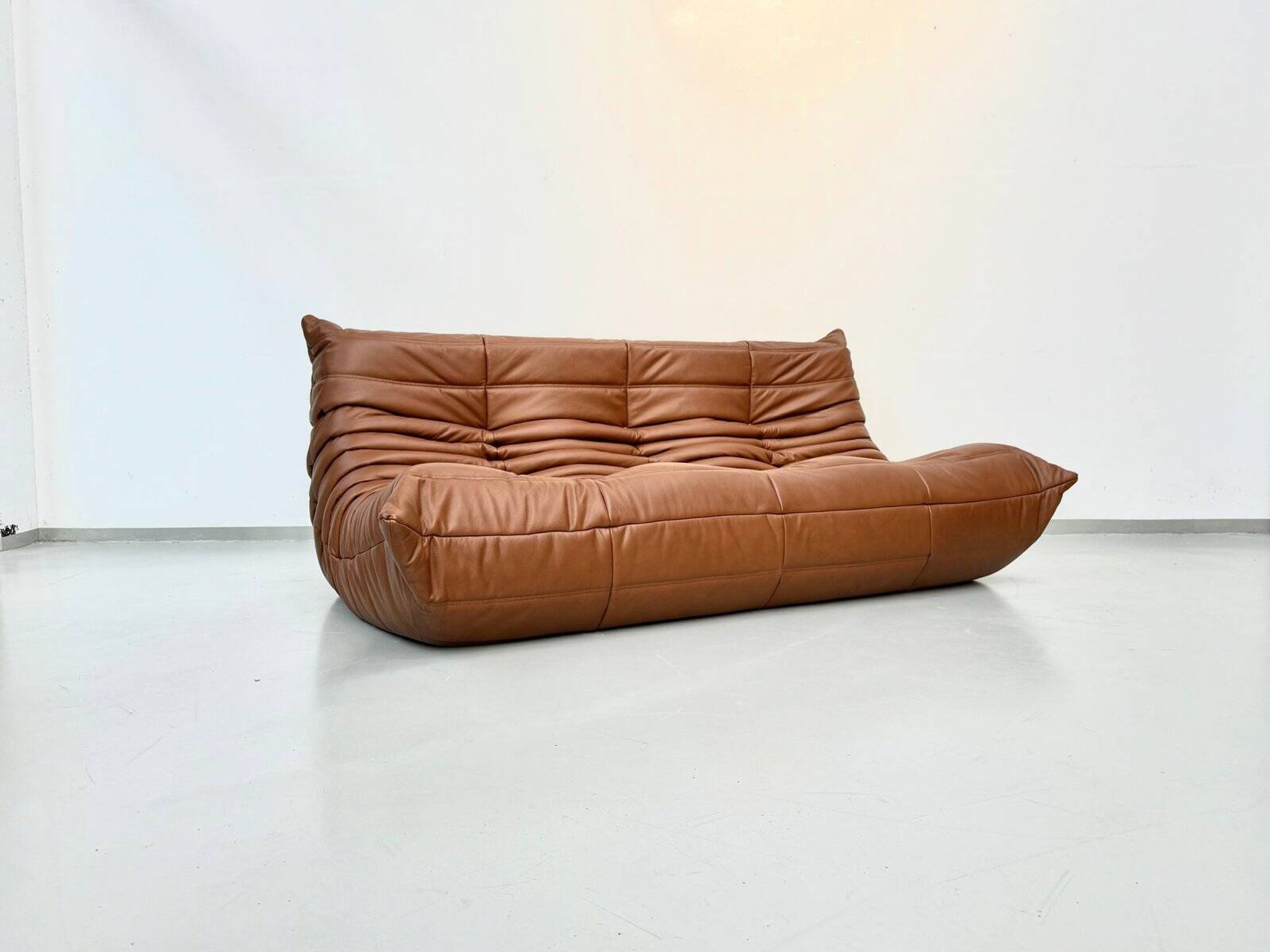 Three-seater Togo sofa in dark cognac leather by Michel Ducaroy for Ligne Roset.