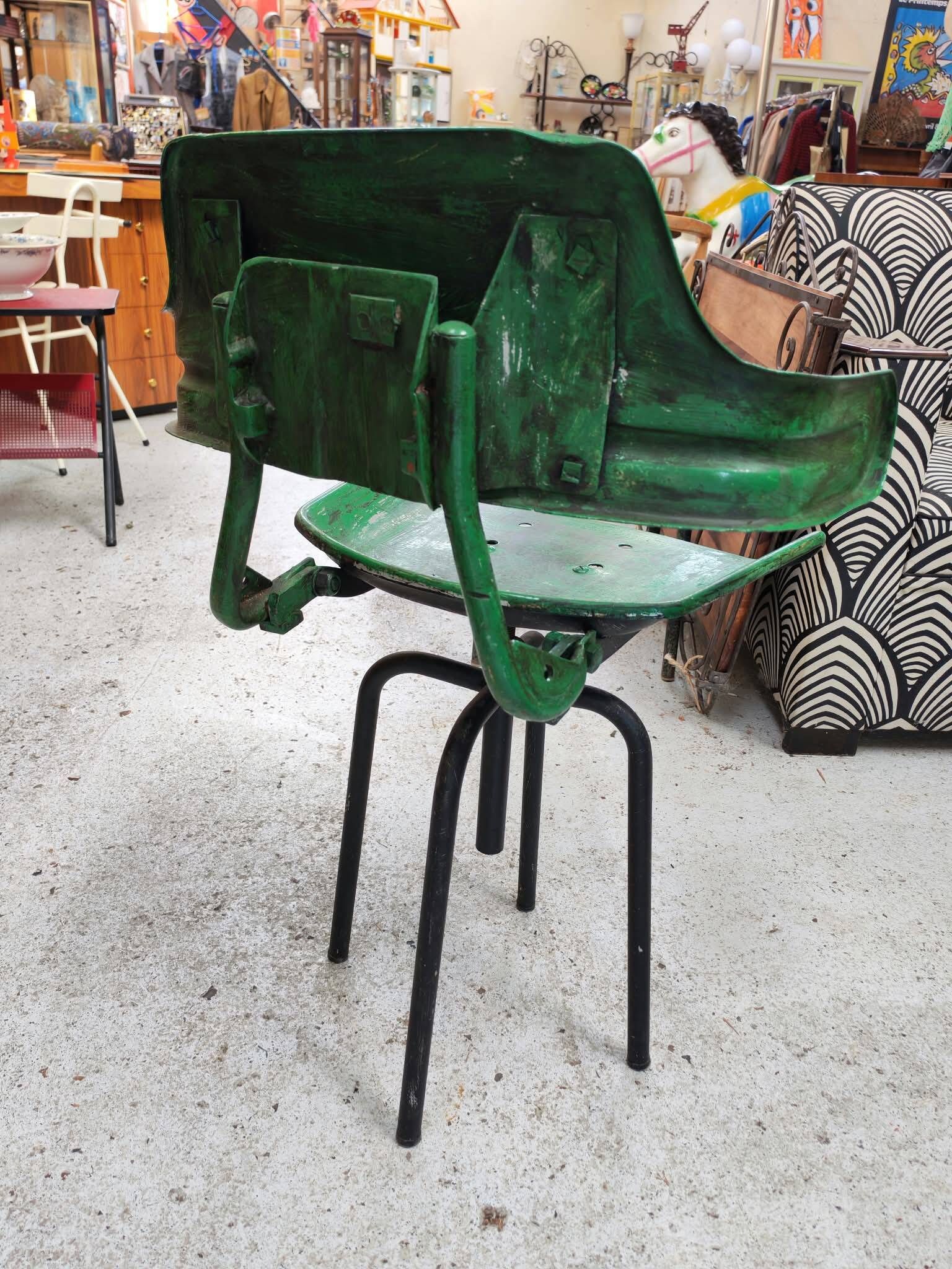 Vintage swivel workshop chair in green pressed sheet metal with a folding backrest.