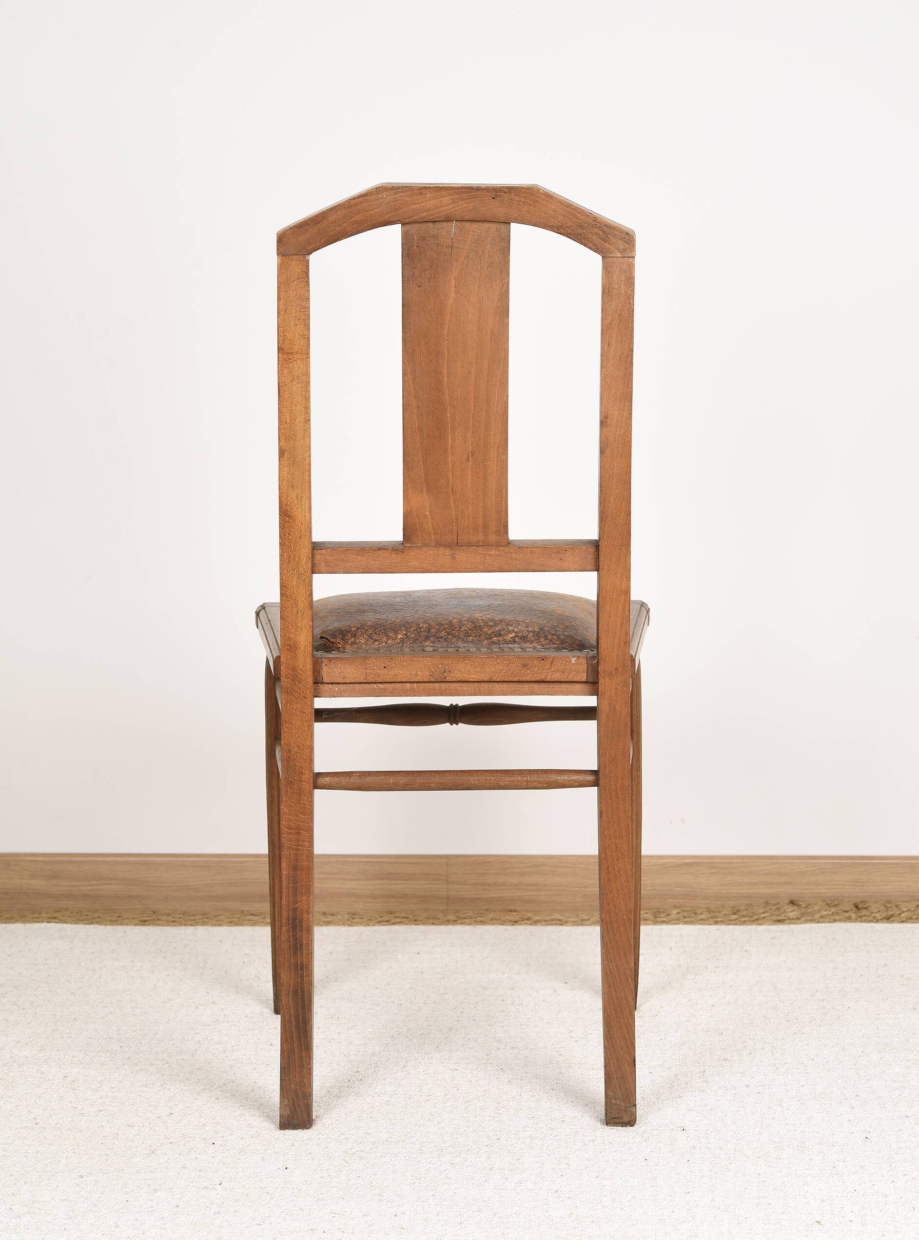 Art Deco style chair in carved wood and leather.