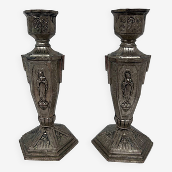 pair of silver metal candlesticks decorated with virgin