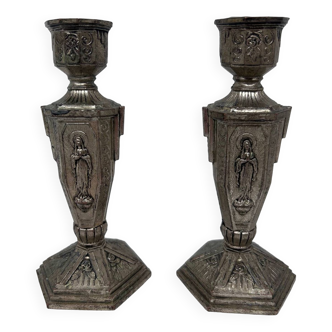 pair of silver metal candlesticks decorated with virgin