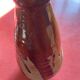 Large antique pottery bottle in glazed terracotta with drips.