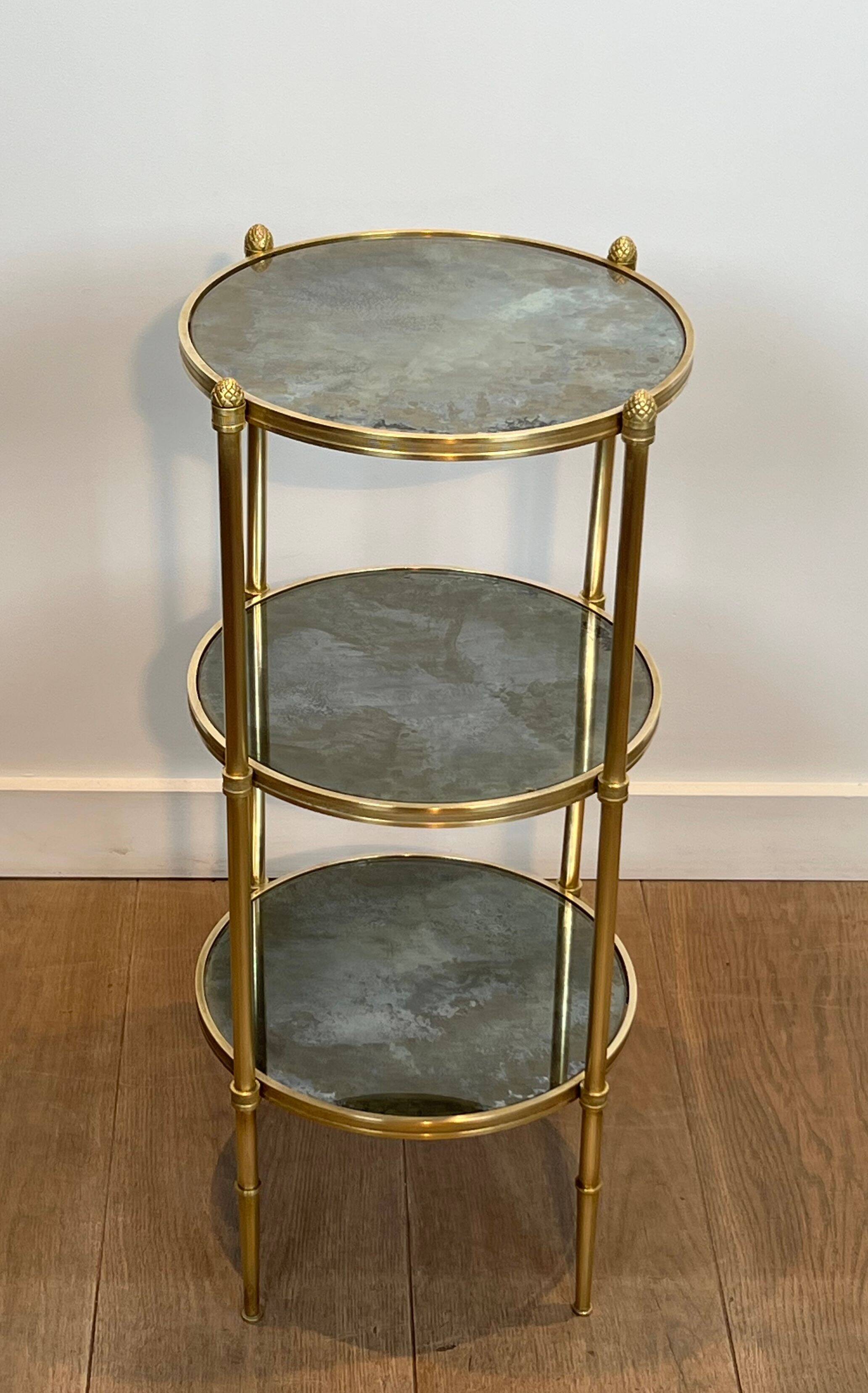 Round bronze side table with triple shelves of églomisé mirrors from Maison Baguès