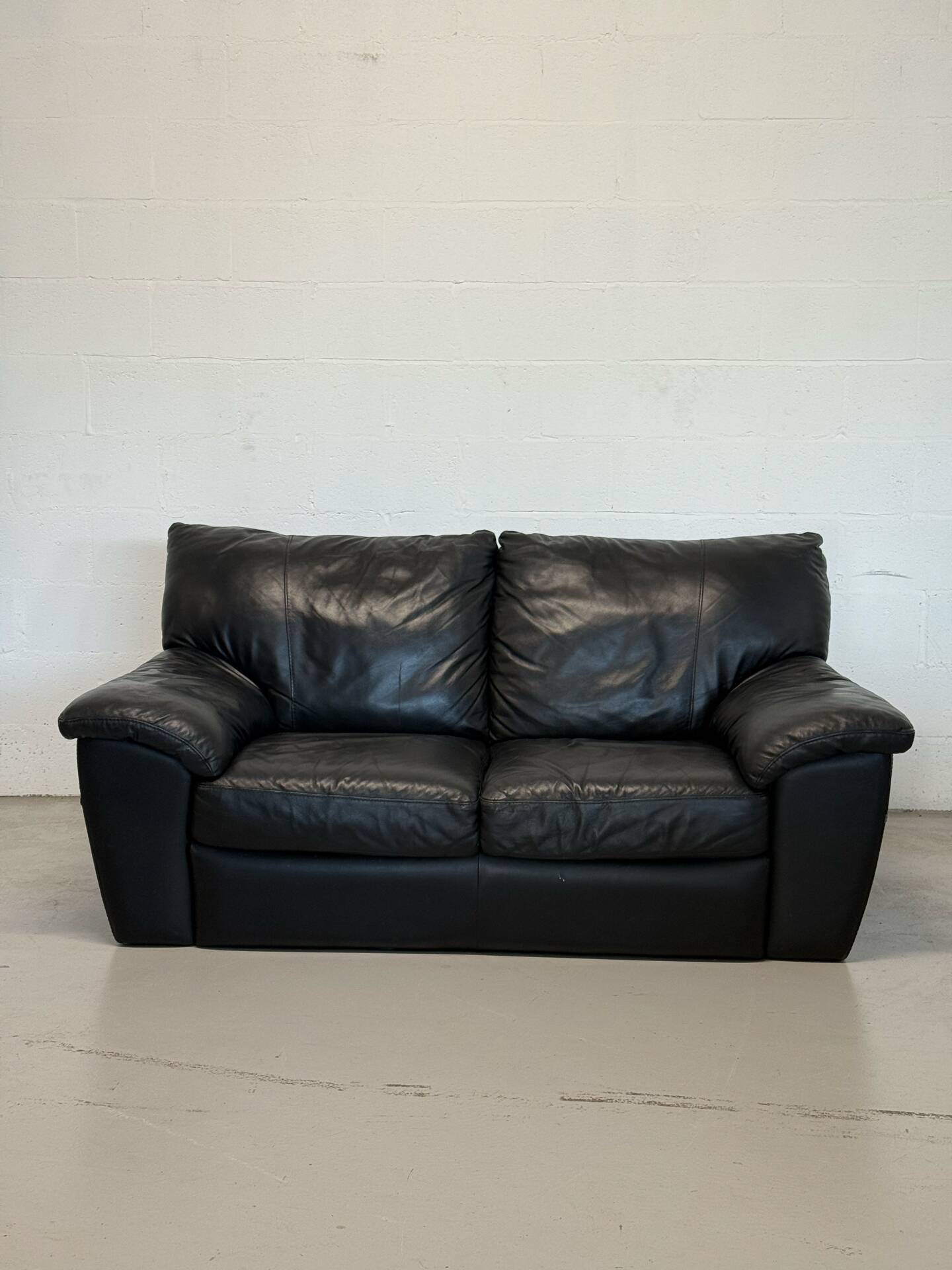 Two-seater black leather sofa — postmodern design