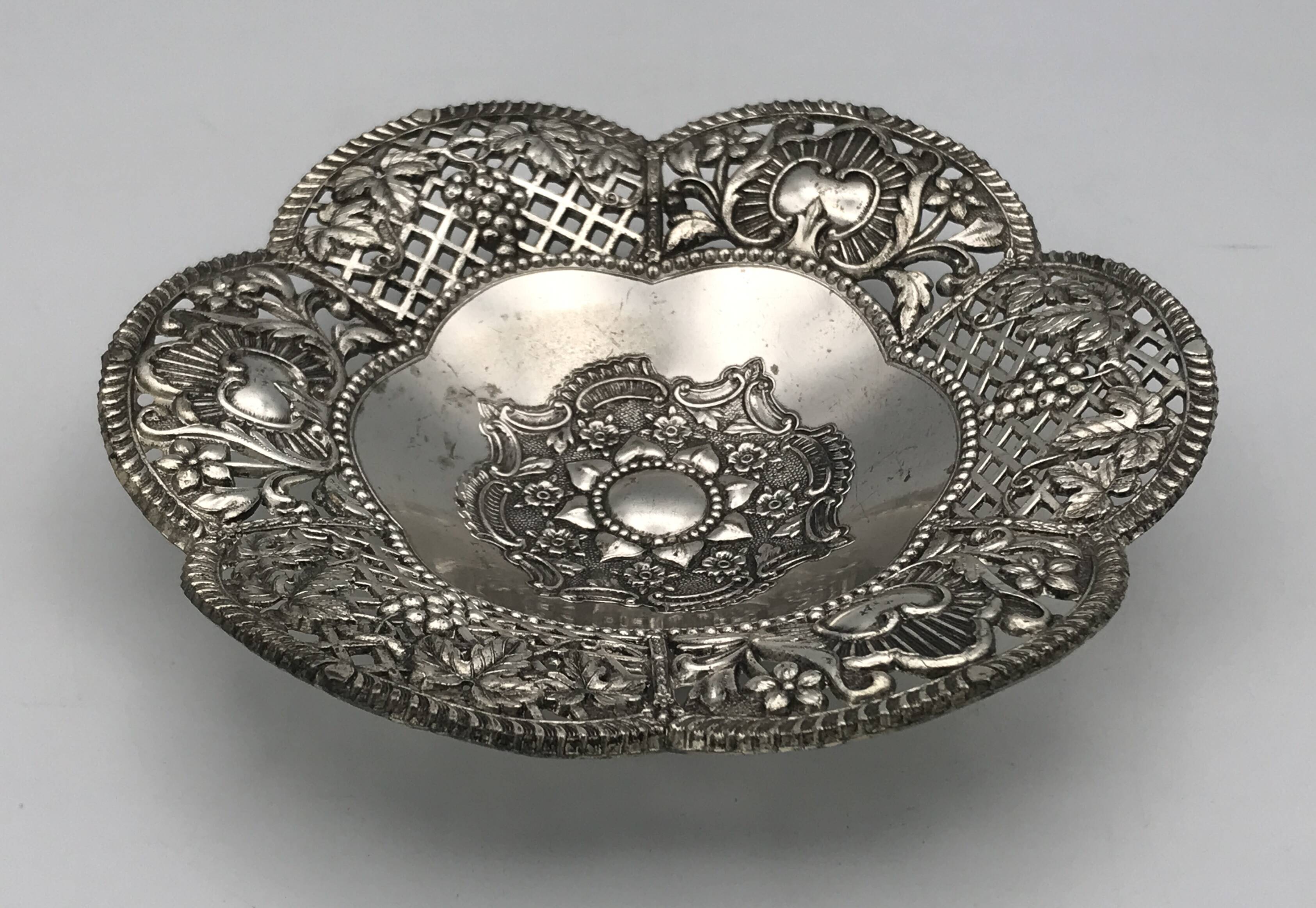 Silver-plated metal pocket emptier with openwork outline decoration