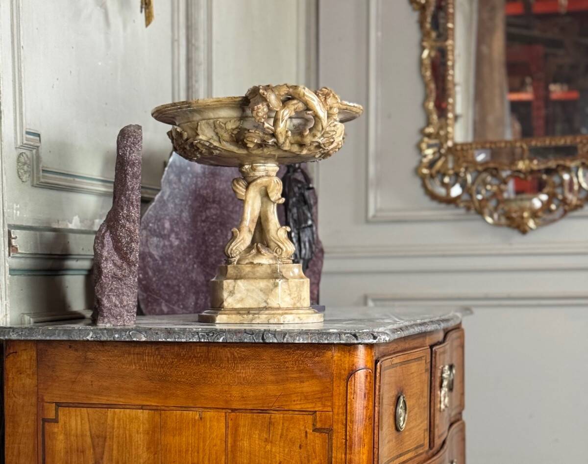 Alabaster bowl decorated with vine leaves on a base of three dolphins, circa 1880.