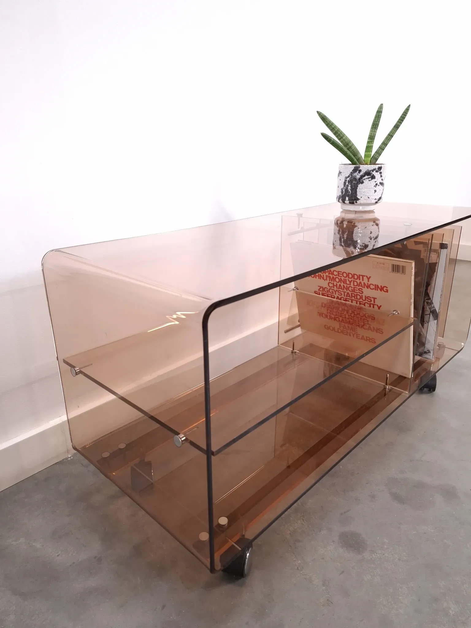 Vintage hifi, LP cabinet, TV unit made of tinted plexiglass on wheels, records.