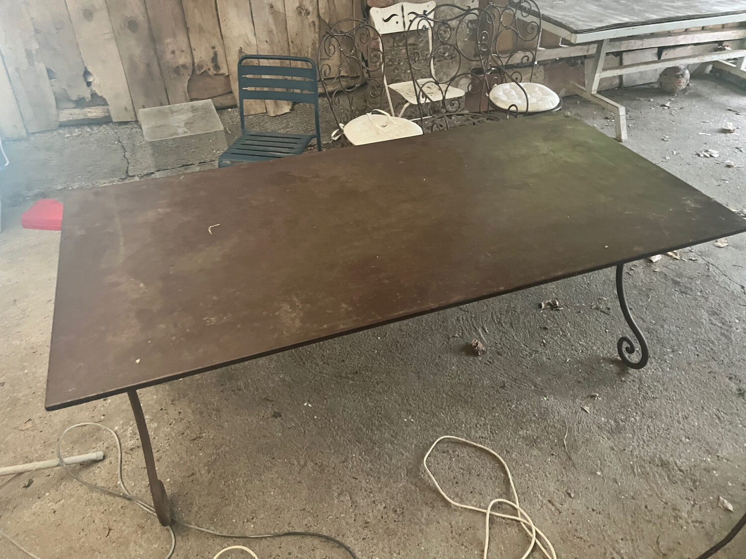 Old wrought iron table and its armchairs and chairs for outdoor use.