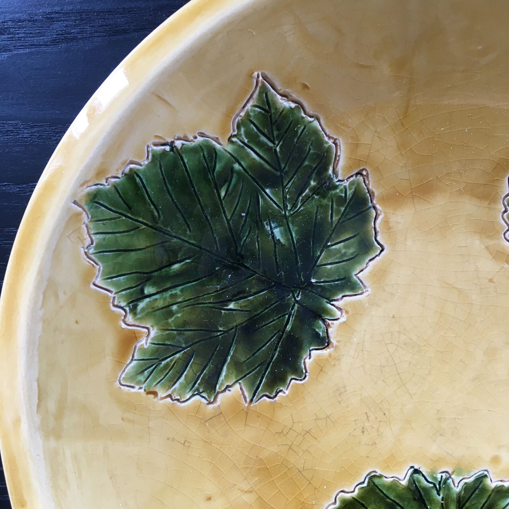 Plate signed with green leaf decoration.