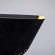 Matte black wall lamps with perforated shades and brass details