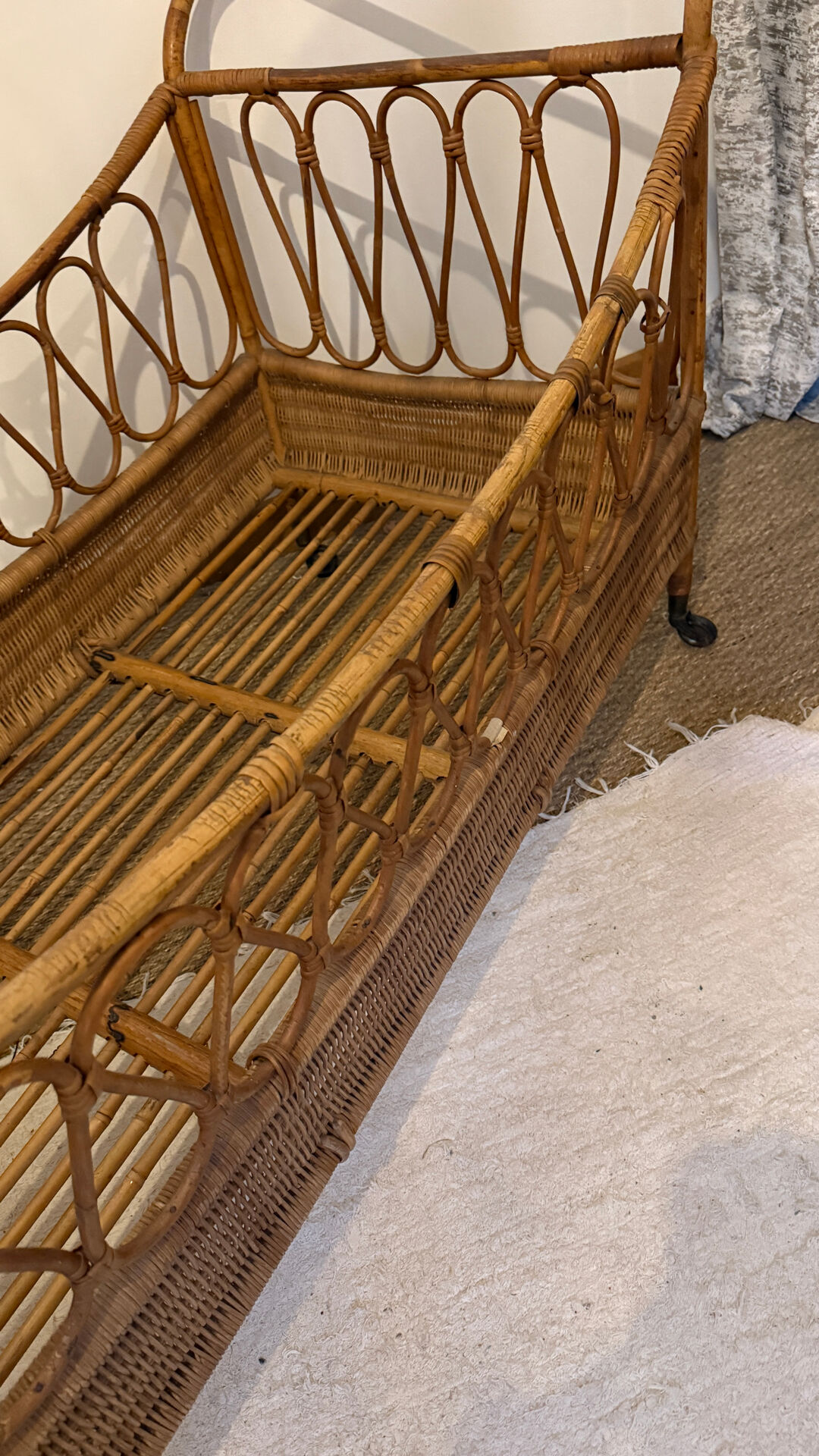 Vintage rattan baby cot on wheels.