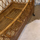 Vintage rattan baby cot on wheels.