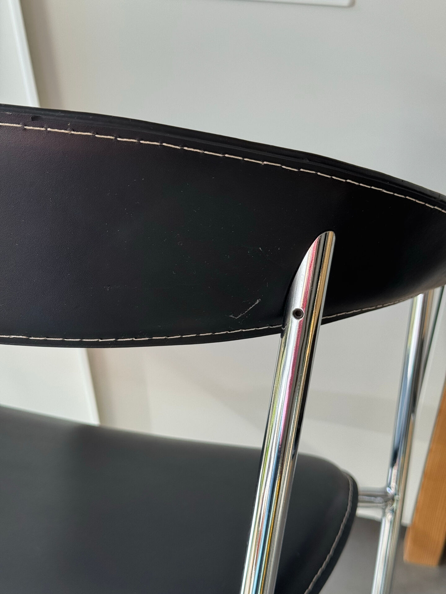 Set of two metal chairs with a brushed finish and black leather.