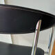 Set of two metal chairs with a brushed finish and black leather.