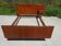 Teak bed with integrated bedside table in Scandinavian style.