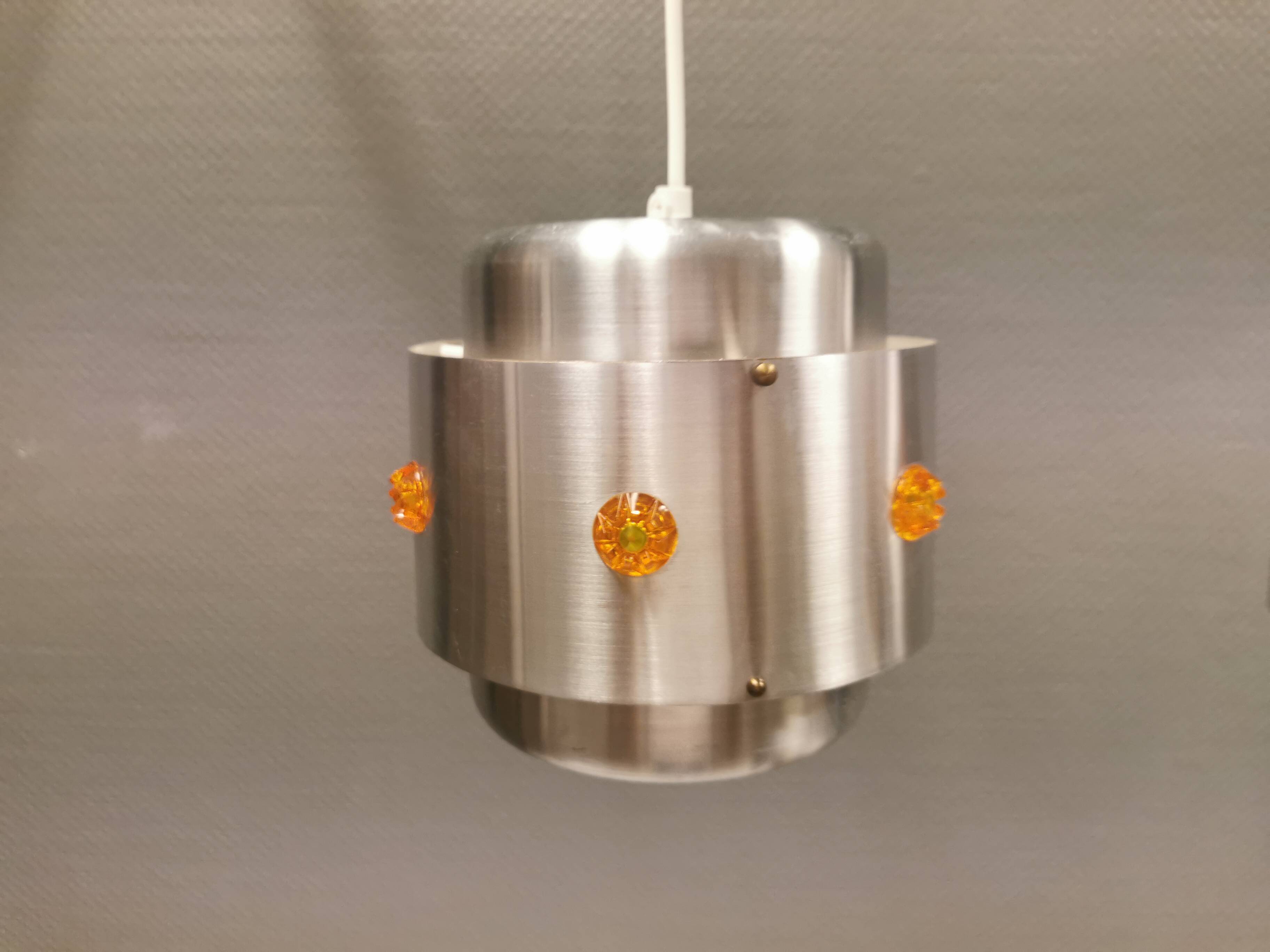 Two Space-Age hanging lamps, in silver-coloured aluminium with orange prisms.
