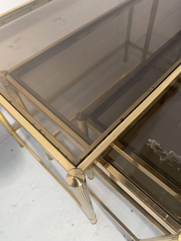 Suite de trois tables gigognes de style en laiton et verre fumé XX siècle