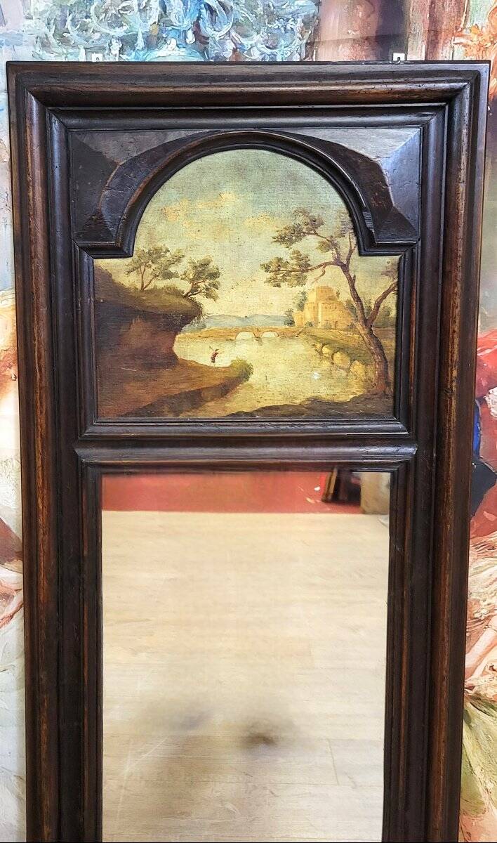 Dark wood trumeau with a mirror and landscape painting.