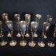 Lot of 12 silver metal flutes on brass stand
