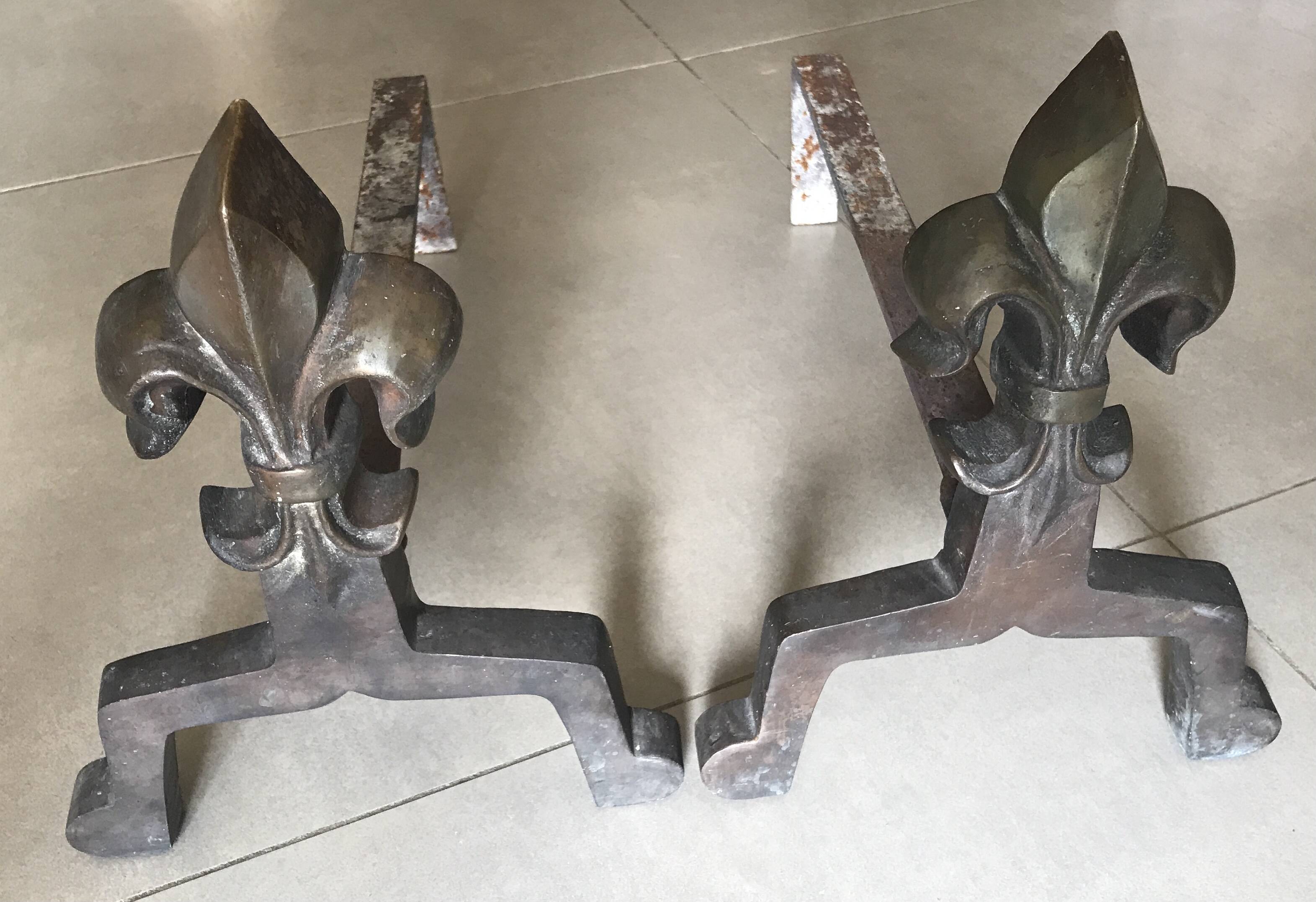 Pair of bronze fireplace firedogs with fleur-de-lys decor, art deco