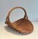 Woven Rattan Log Holder in a Semi-Round Shape with a Central Arched Handle.