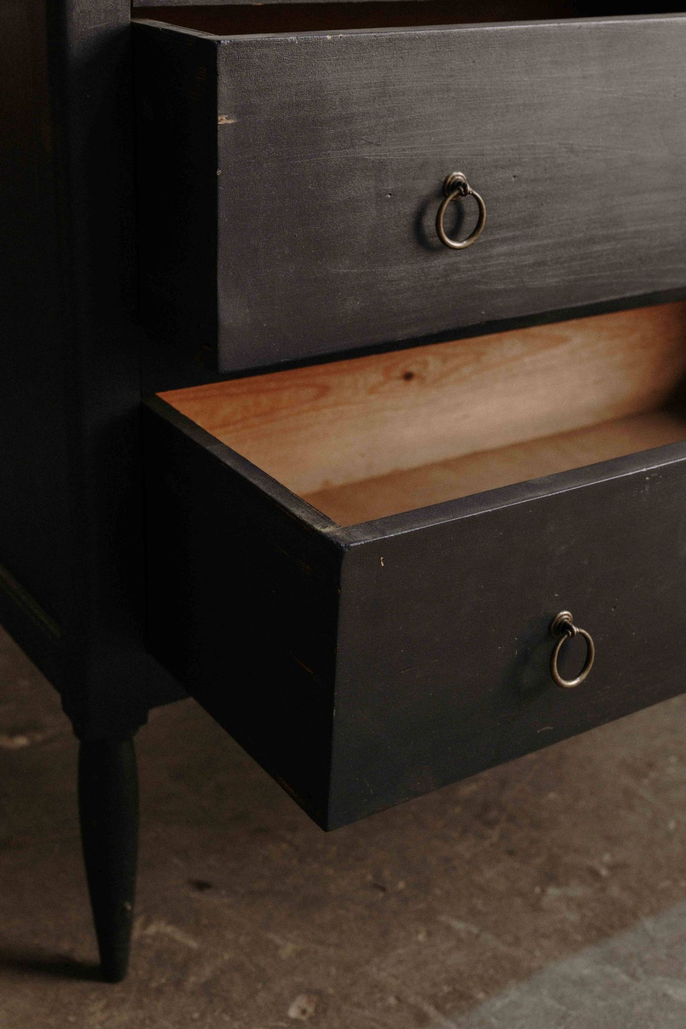 Commode noire à 2 tiroirs, plateau en bois brut et pied fuselés