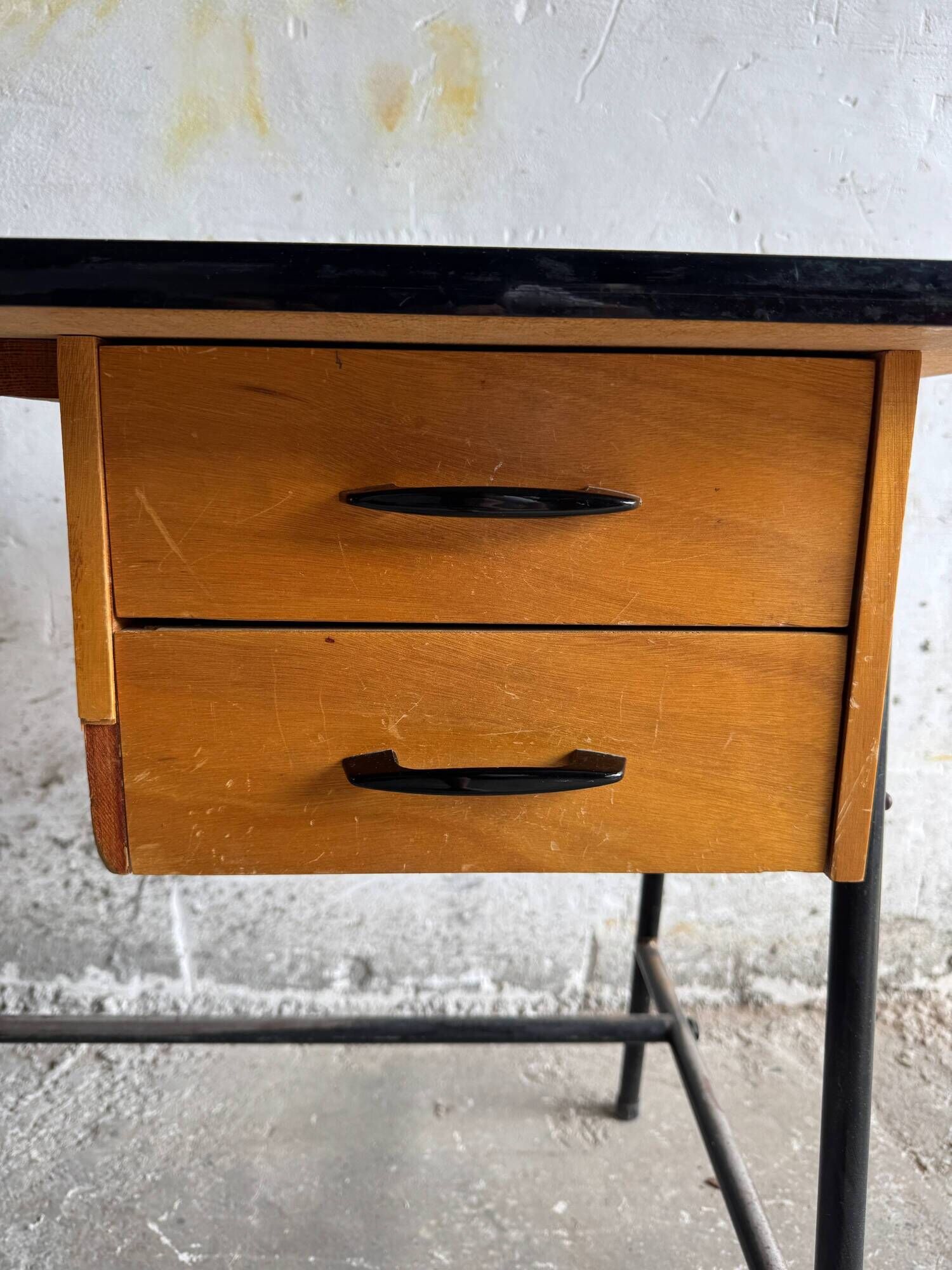 Black metal and wood mid-century industrial desk with laminated top and two drawers