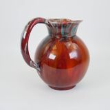 Large red and blue glazed ceramic pitcher signed Delène under the base