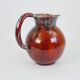 Large red and blue glazed ceramic pitcher signed Delène under the base