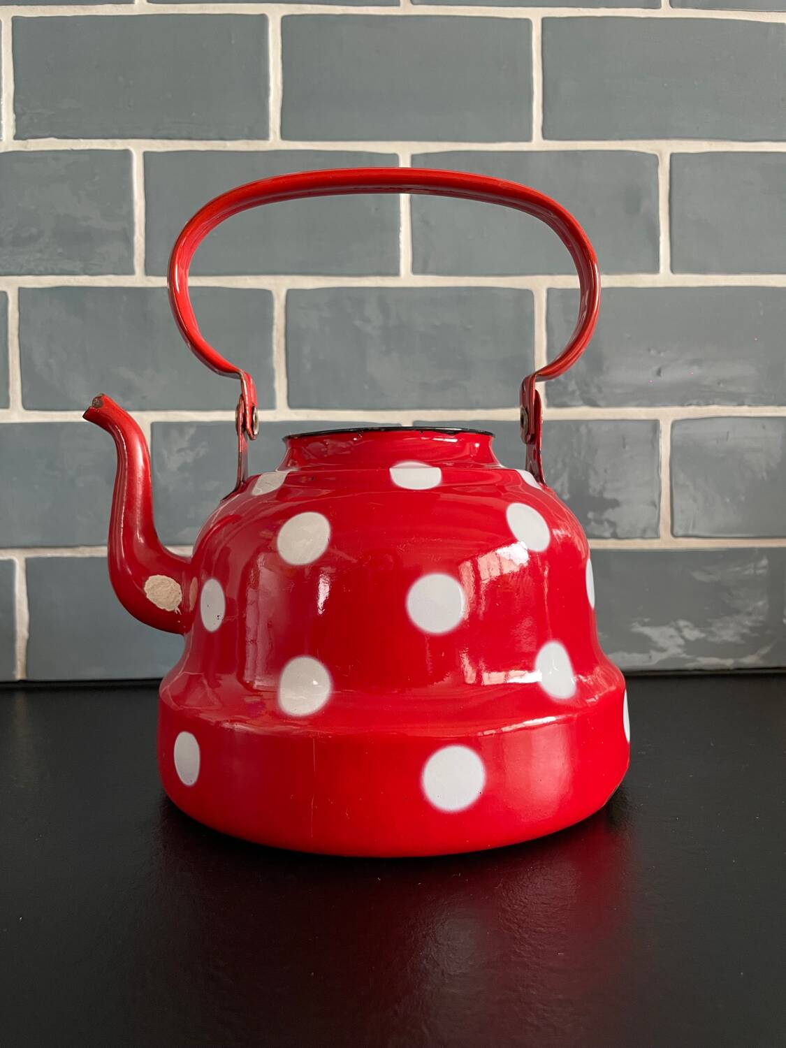 Red enameled sheet metal kettle with white polka dots