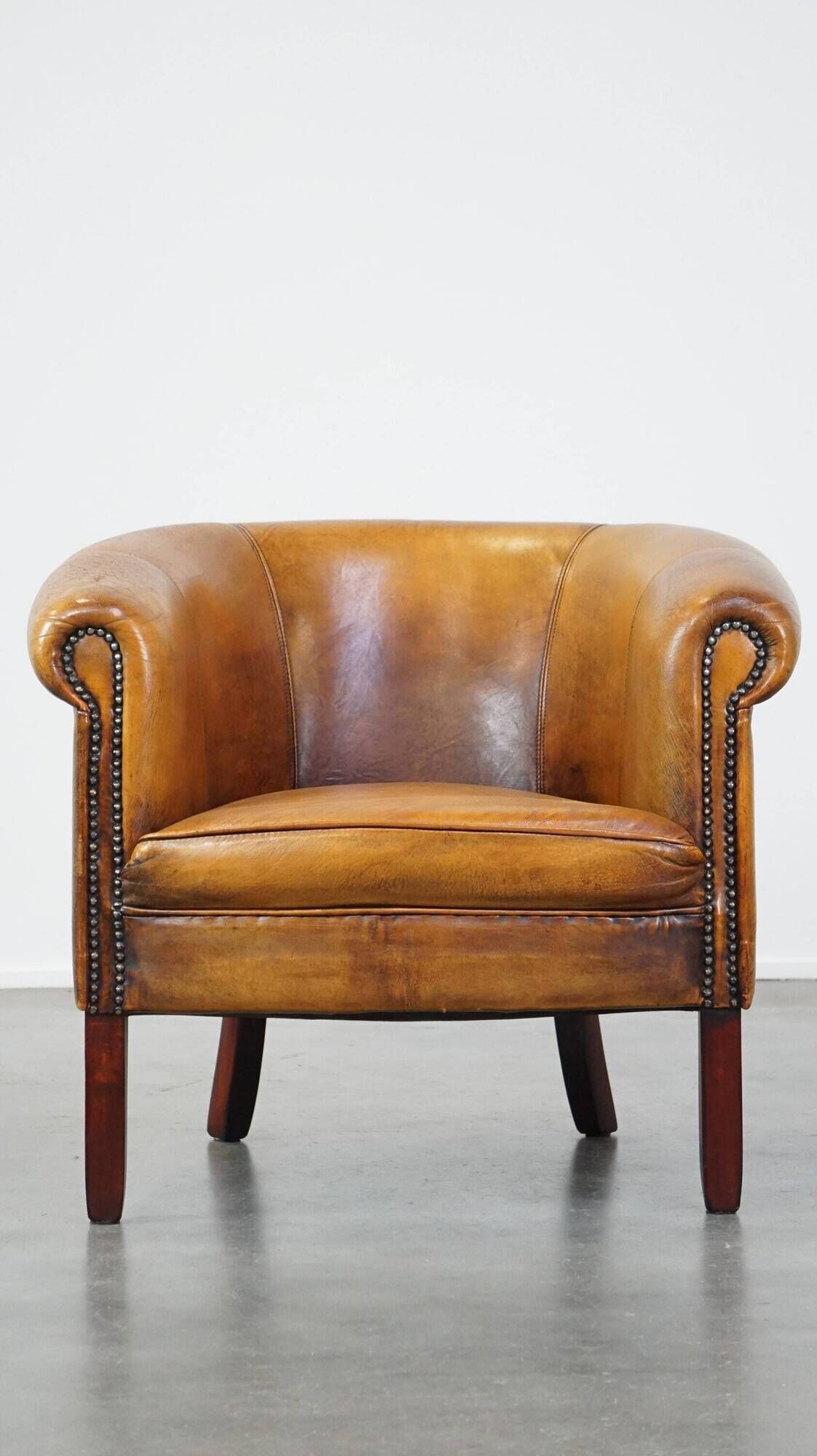 Fauteuil club en peau de mouton subtile avec finition cloutée décorative