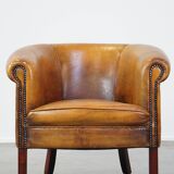 Subtle sheepskin club chair finished with decorative studs