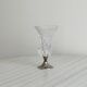 Small vase on a metal stand with thick glass.
