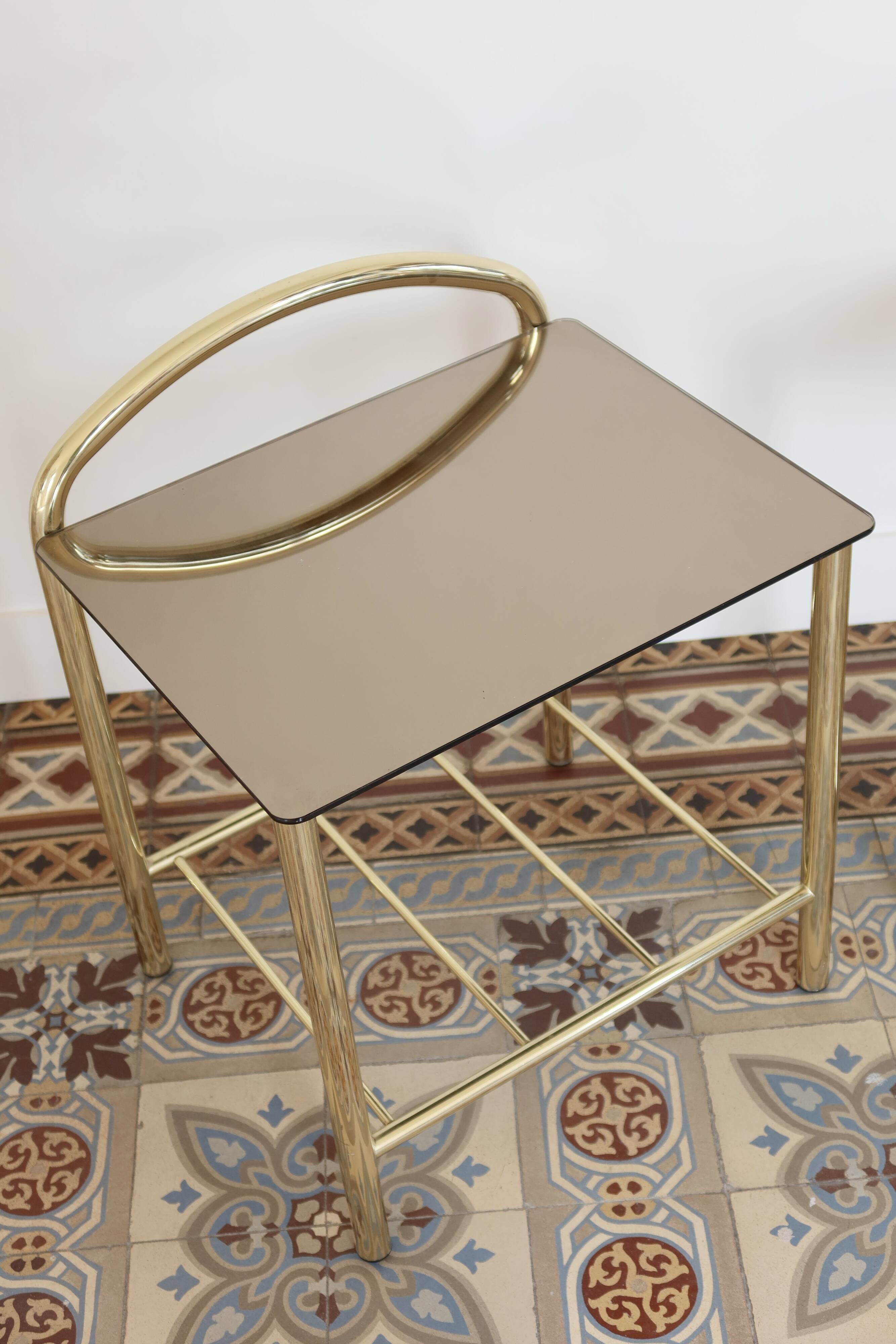 Pair of bedside tables with gold metal and mirrored glass top.