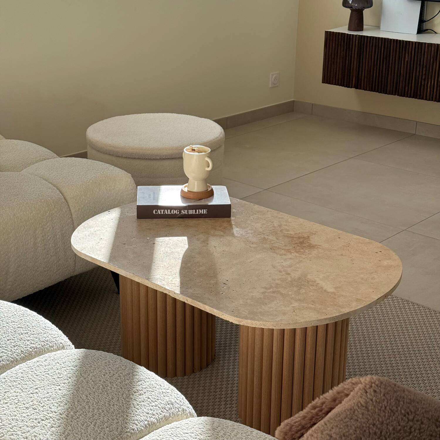 Oval coffee table duo travertine and raw fluted wooden legs.