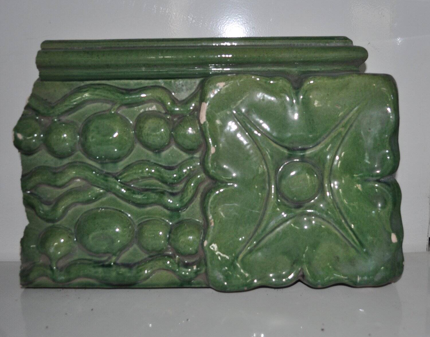 Green enamelled ceramic stove tile — finely sculpted Hungarian pattern from the late 19th century.