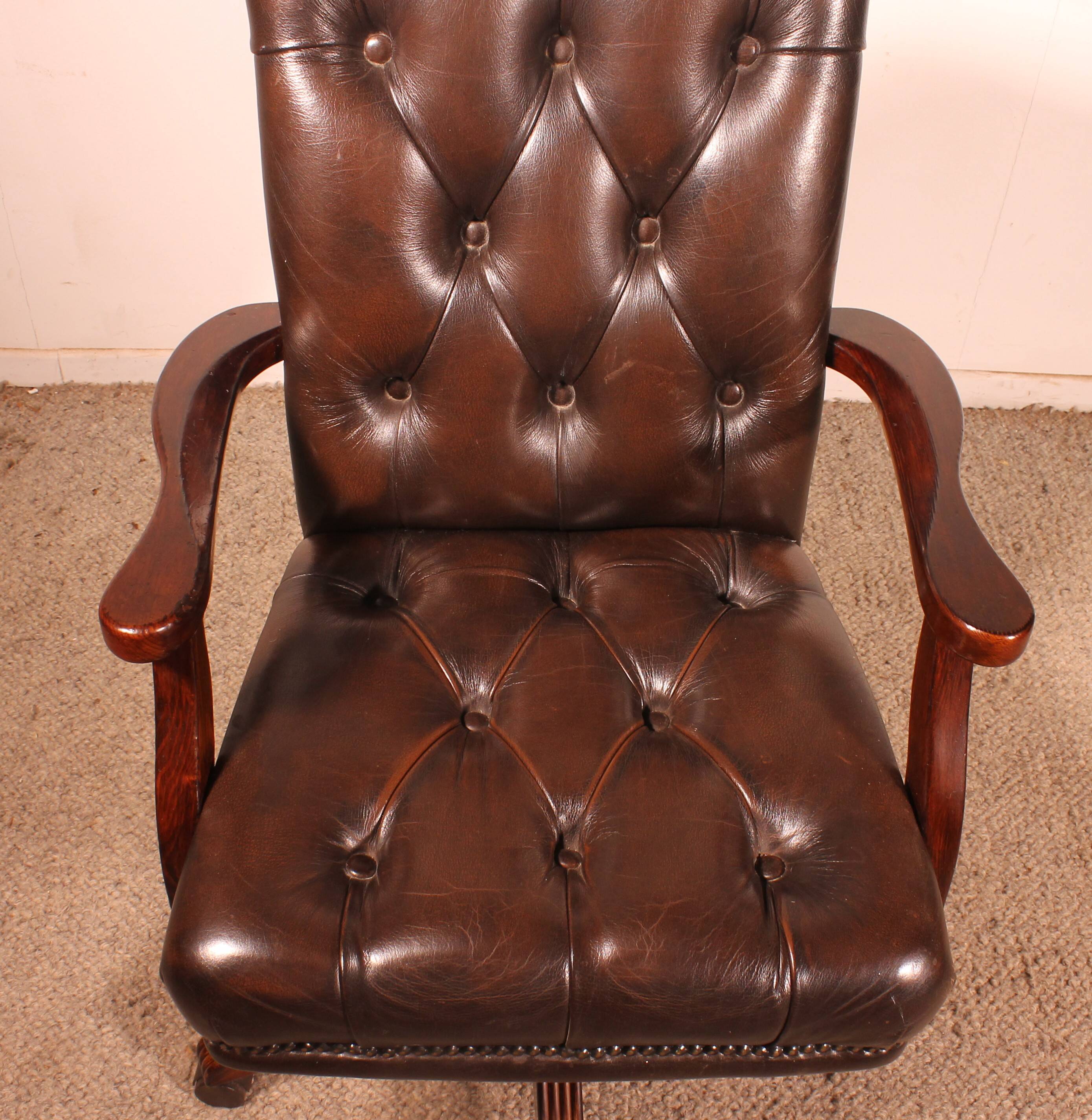 Office chair known as a director's chair in wood and tufted leather.