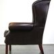 Chesterfield wing chair in dark brown leather with a luxurious appearance