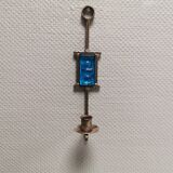 Wall-mounted candle holder in cast iron and hard pressed blue glass.