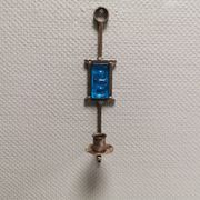 Wall-mounted candle holder in cast iron and hard pressed blue glass.