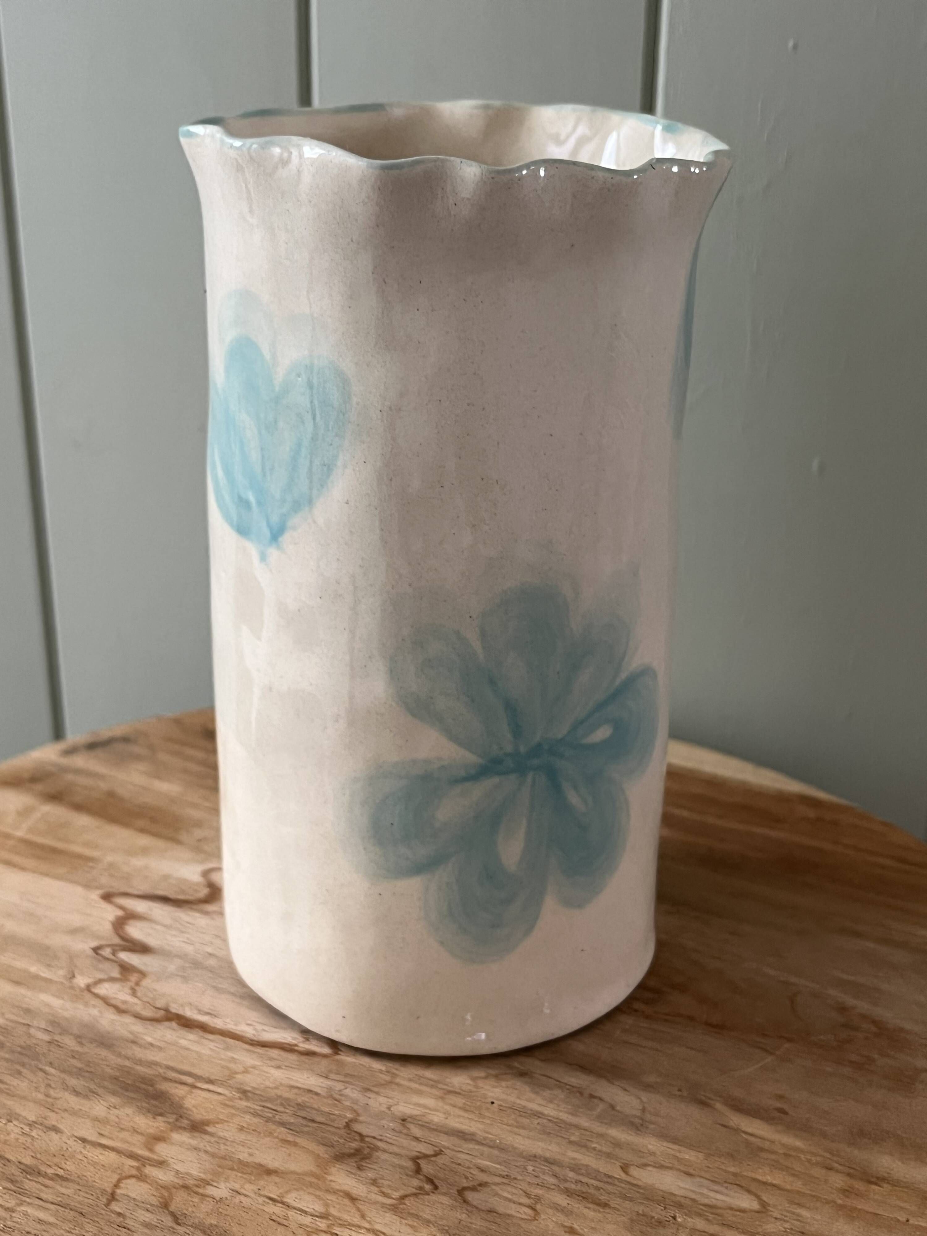 Stoneware vase decorated with flowers in a watercolour style.