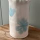 Stoneware vase decorated with flowers in a watercolour style.