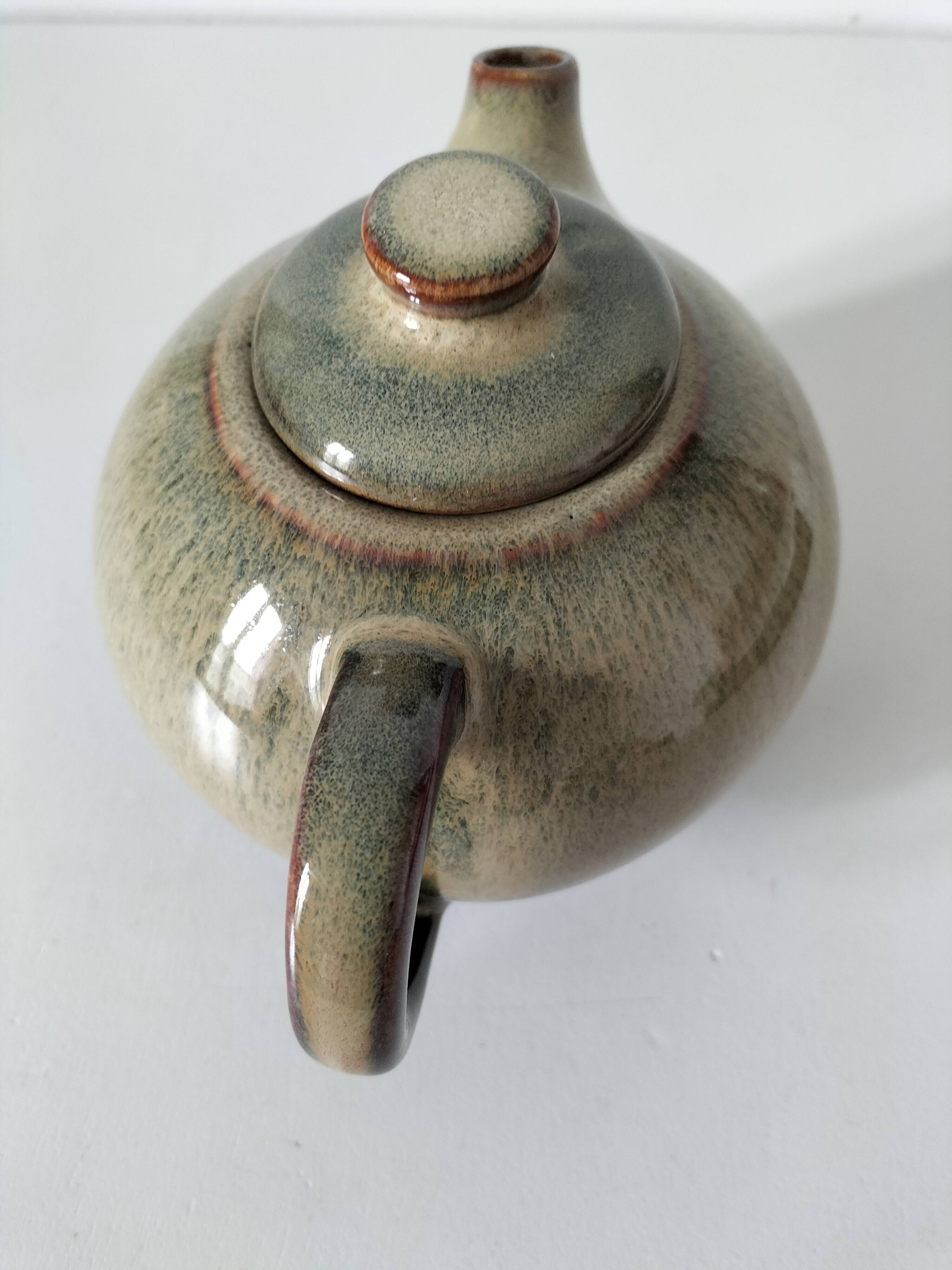 Vintage ceramic teapot with a flame design.