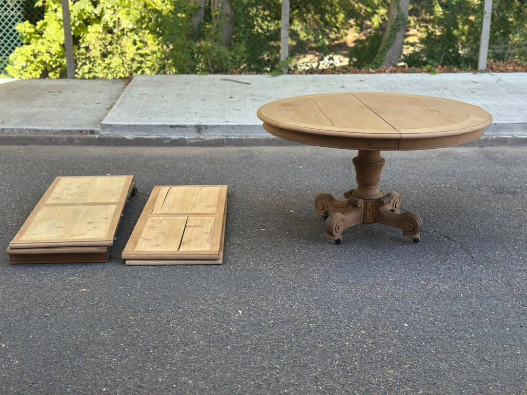 Round dining table with a central pedestal, stripped raw oak, 4 extensions, 19th century.