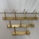Three vintage 1960s gold coat racks with 4, 3 and 2 hooks