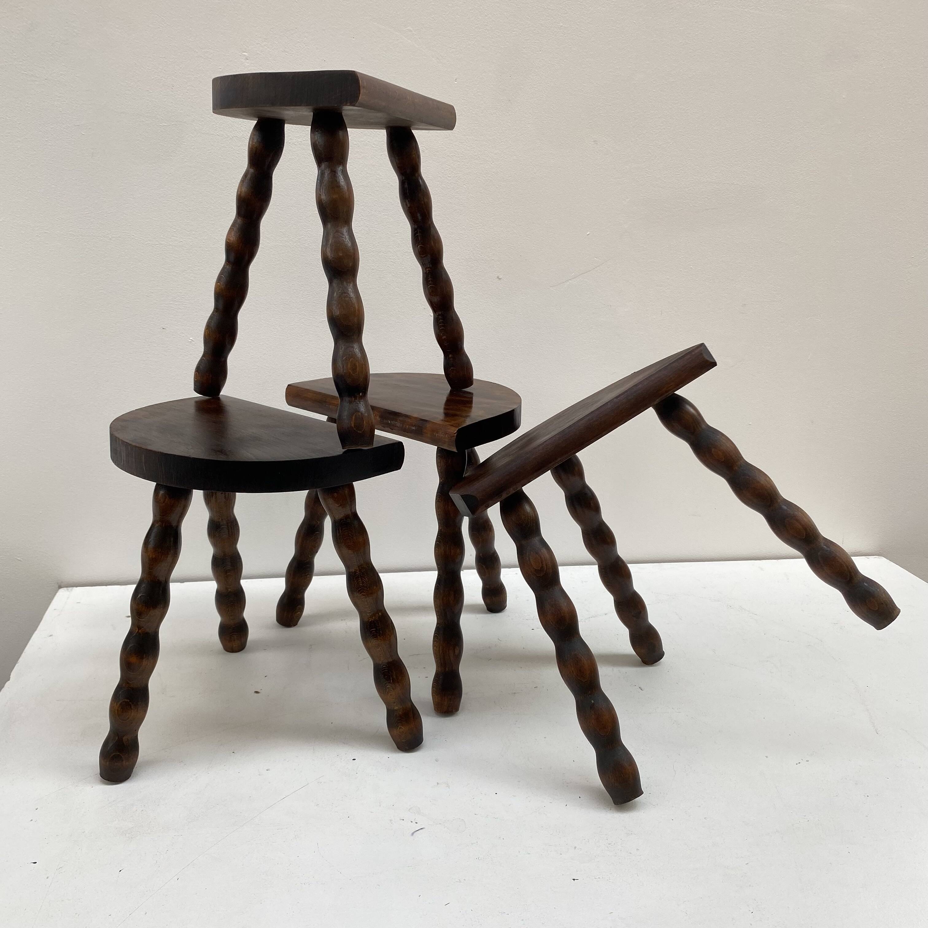 Series of 4 small tripod stools with half-moon seat and beaded turned wood legs